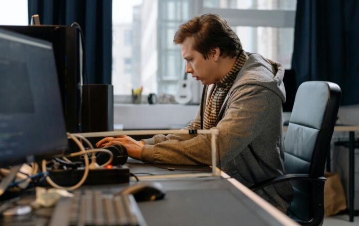 Free A concentrated professional working at a computer in a modern office setting. Stock Photo