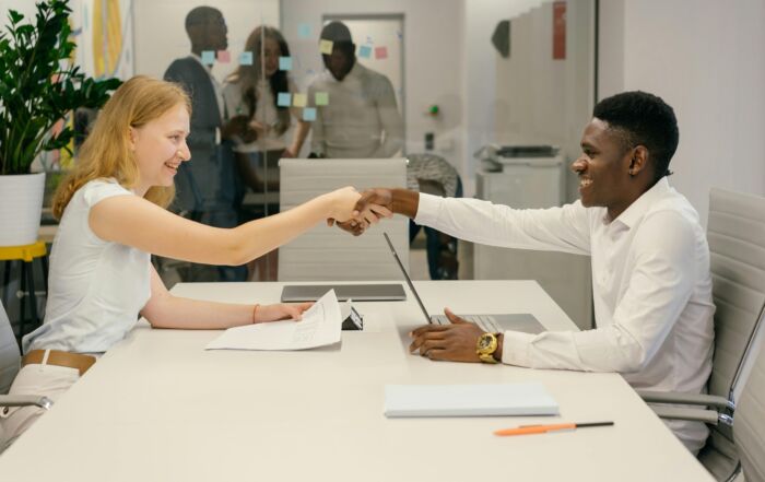 Free Business professionals completing a successful deal with a handshake in a modern office setting. Stock Photo